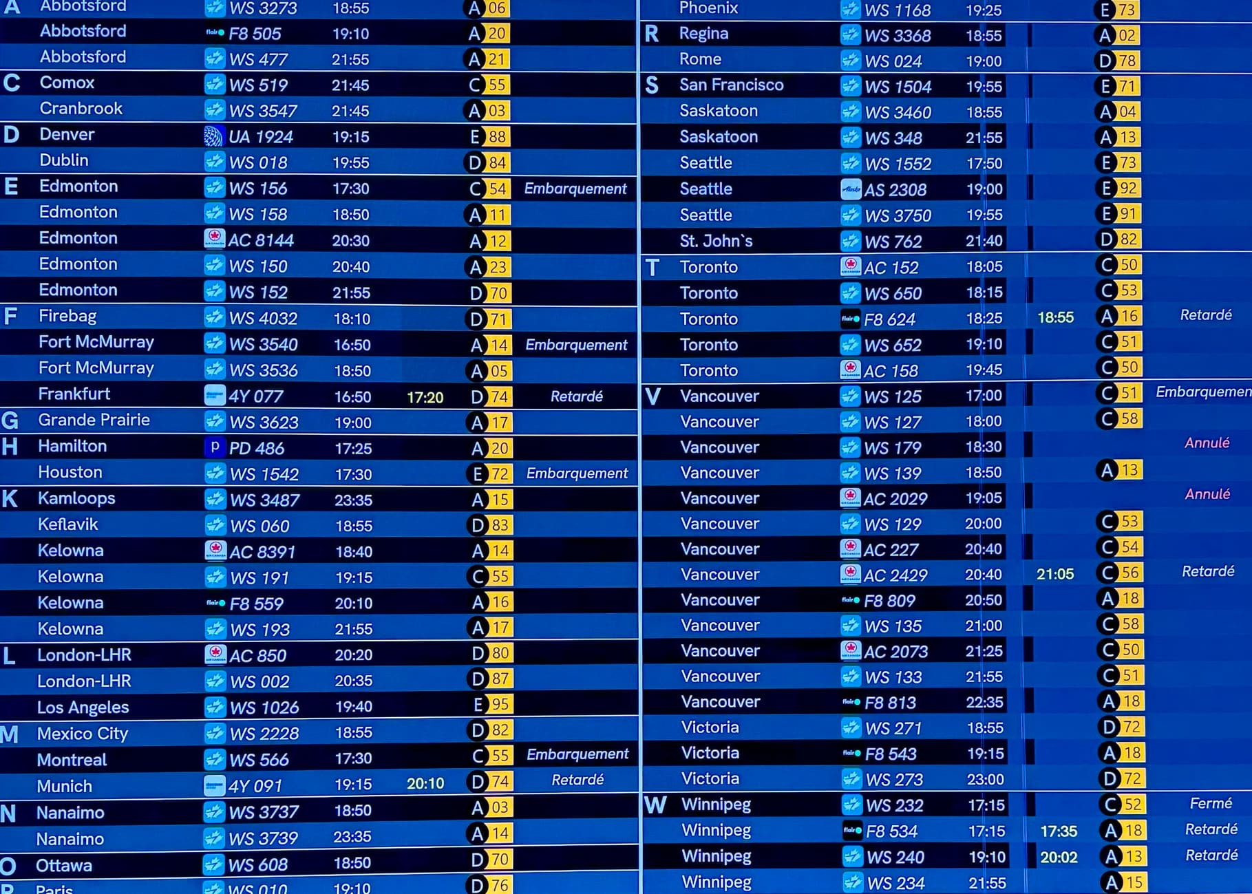 Blue airport departure board heavy with Canadian destinations organized first alphabetically by city of arrival, then by time