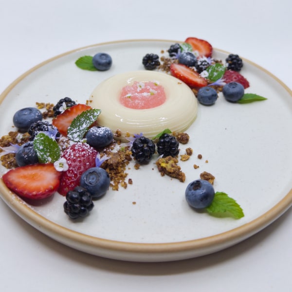 White half-torus filled with pink gel flanked by berries, mint, crumble, high key white background