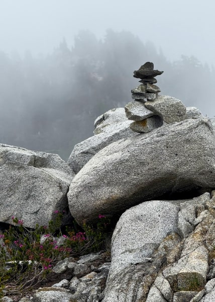 Small stacked rocks on boulders in the fog